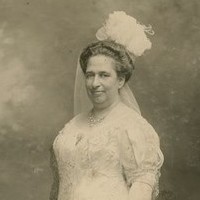 Image: black and white photo of woman standing in white dress and veil