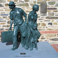 Image: bronze sculpture of family group with suitcase