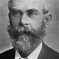 Image: A photographic portrait of a middle-aged man in late-Victoran attire with a salt-and-pepper beard and thinning hair