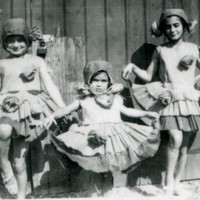 Image: Three girls in costume with pom-poms attached to skirts