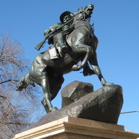 Image: The statue of a horse and rider mounting the crest of a hill