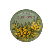 Image: A small circular badge with painted wattle flowers with text above them which says for our own