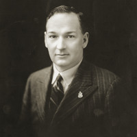 Image: Black and white portrait photograph of the upper body of a man dressed in formal attire