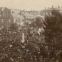 Image: crowds surrounding stone statue of standing man