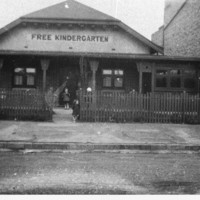 Image: two children standing in front of a cottage kindergarten