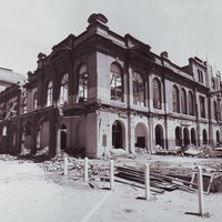 Image: An exterior view of a large building in the process of being demolished. The roof has been taken off, glass has been removed from the windows and all the interior walls have been knocked down.