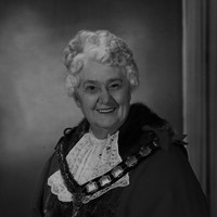 Woman wearing mayoral robes and wig. 