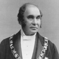 Image: Black and white photograph of man wearing formal clothes and livery collar