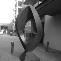 Image: steel quadrangle-shaped sculpture with rounded edges and a geometric hole in the middle