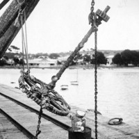 Image: large metal anchor suspended over jetty