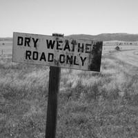 Image: Outback landscape and road with sign, stating 'Dry weather road only'