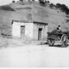 Image: Horse and cart in front of run-down toll house building