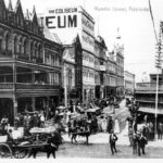 Image: Bustling street with ornate building and balcony