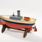 Image: toy boat made of metal and painted red, blue and cream