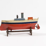 Image: toy boat made of metal and painted red, blue and cream