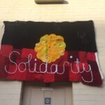 Image: knitted Aboriginal flag