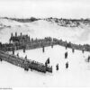 Image: Photograph of uniformed soldiers on active parade in the middle of sandhills