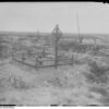 Image: black and white photograph of 10th Battalion cross and place marker fence in a remote field