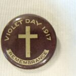 Image: purple badge with white cross and text