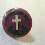 Image: purple badge with green cross and text