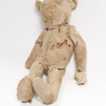 Image: worn teddy bear with stuffing showing