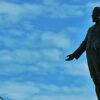 Image: sculpture of standing man silhouetted in sky