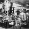 Image: A number of glass cabinets display a variety of items. Signs on the wall behind them reveal them to be items from New South Wales and South Australia.