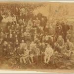 Image: a group of people gathered by a tree in a park