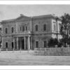 Image: Front of large, two-storey historic building with columns bordering its front door