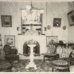 Image: Black and white photograph of interior of room, with floral-print furniture and wallpaper