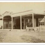 Image: A line of shops with verandahs lining a dirt road.