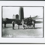 A group of men with cart standing outside the masonry perimeter wall of the copper smelter