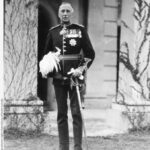 Image: Informal portrait of South Australia's new Governor, taken on the day of his swearing in. He stands, facing the camera, in full dress uniform including sword, plumed helmet and spurs. On his chest he wears an array of medals and orders.