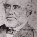 Image: A faded head-and-shoulders photographic portrait of an elderly man with thinning hair and a chin-beard