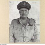 Image: Photographic head-and-shoulders portrait of a middle-aged Caucasian man in the uniform of a high-ranking Australian Army officer