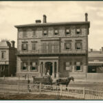 Image: street view of buildings with horse and cart