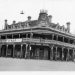 Image: A large three storey corner hotel with a second floor balcony also forming a verandah and gable windows.