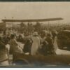 Image: crowd of people surrounding bi-plane on ground