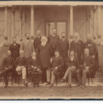 Image: caucasian men in suits pose for a photograph in front of an ornate building