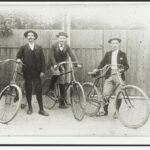 Image: three cyclists in hats pose with their bicycles