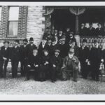 Image: The German consul sitting surrounded by his welcoming party at the front of a house in Hahndorf