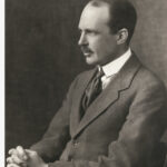 Image: portrait of a seated man wearing suit and tie