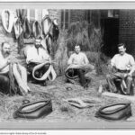 Image: group of men holding and making leather horse collars