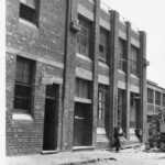 Image: man walking by two buildings