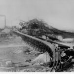 Image: railway tracks approaching slag heap with chimneys and large steel structures visible