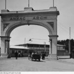 Image: Stone archway and buildings with dirt road in front