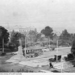 Image: view of a statue in the middle of a road with cars along both sides