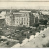 Image: a high angle view of a city street lined with gardens and grand stone buildings