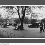 Image: view of people and cars along a street