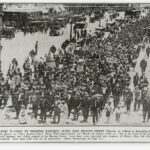 Image: protesters marching down a street holding signs